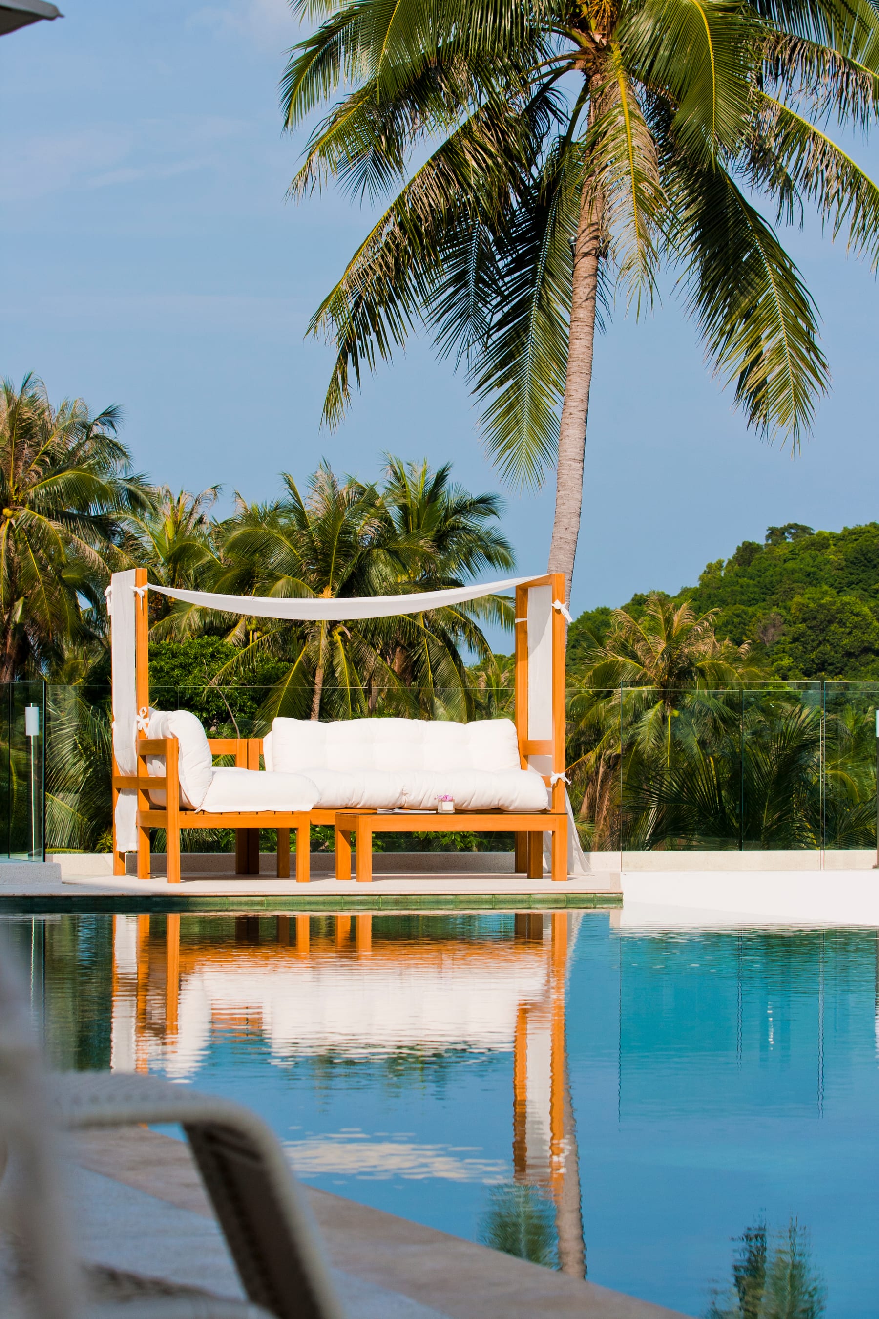 Teak daybed at the edge of the pool