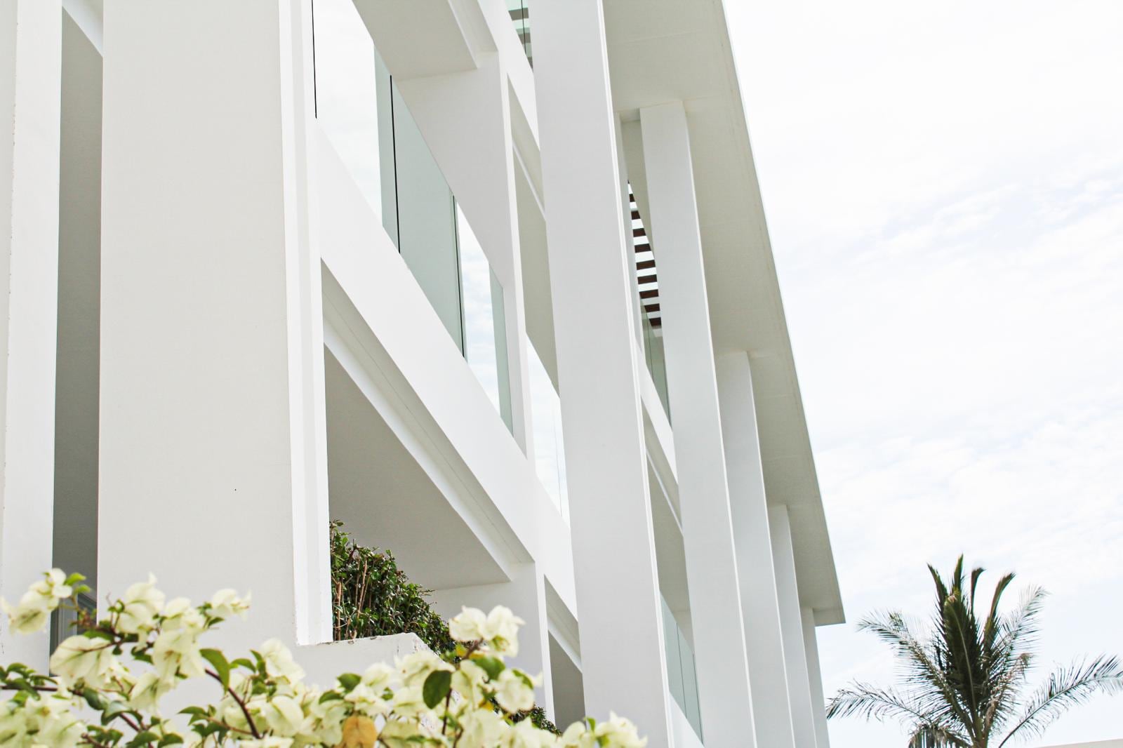 White balconies and bougainvillea on CODE's facade