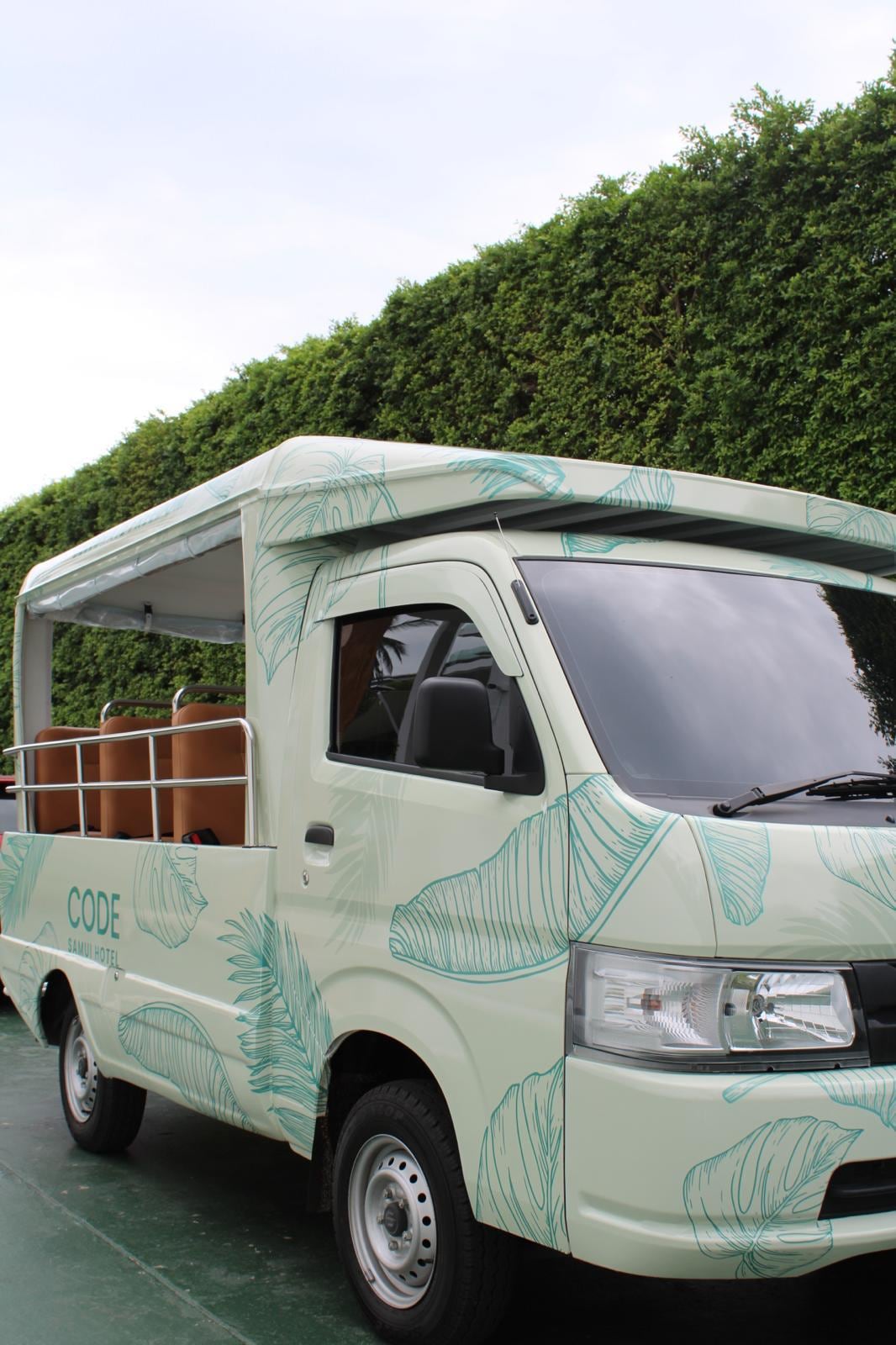 The CODE Tuk Tuk waiting on the drive, palm-leaf livery