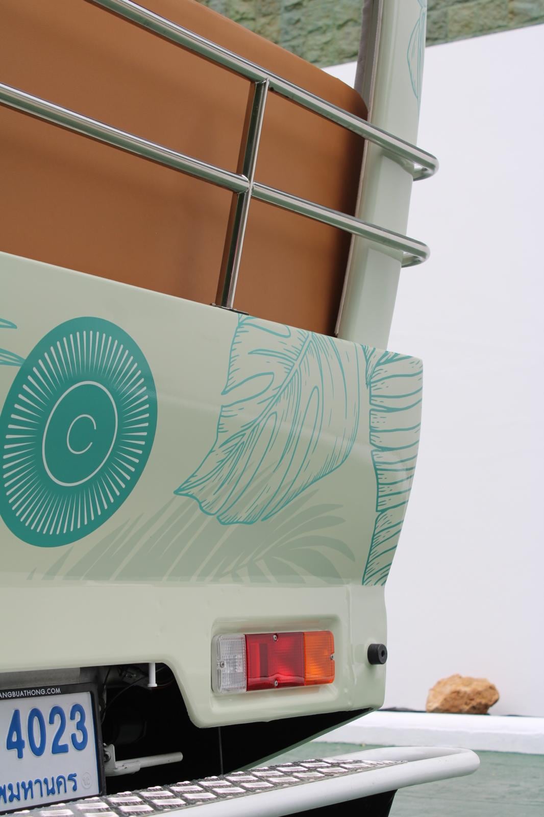 The CODE sunburst medallion on the tuk tuk's tailgate