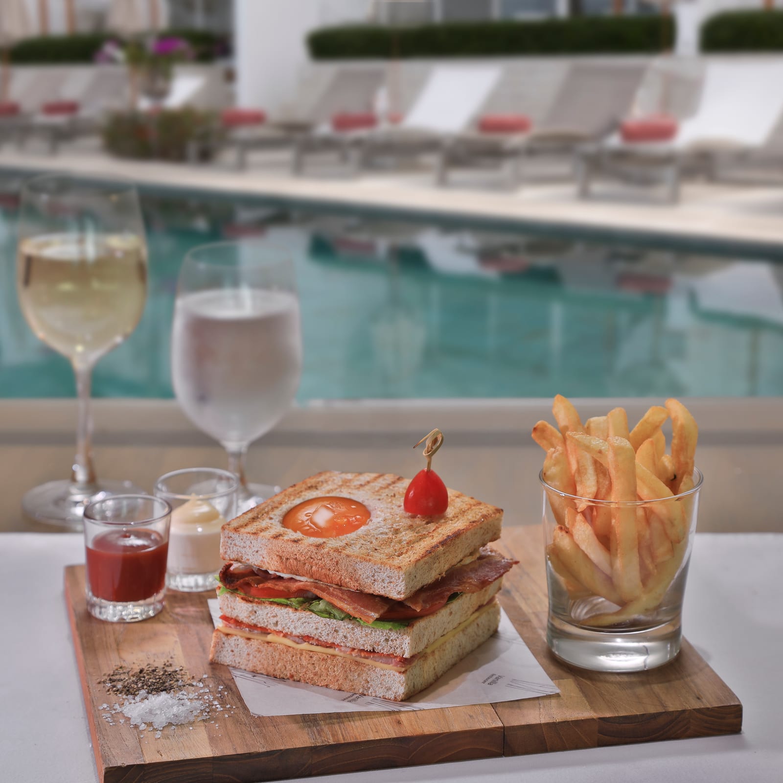 Club sandwich and fries by the pool